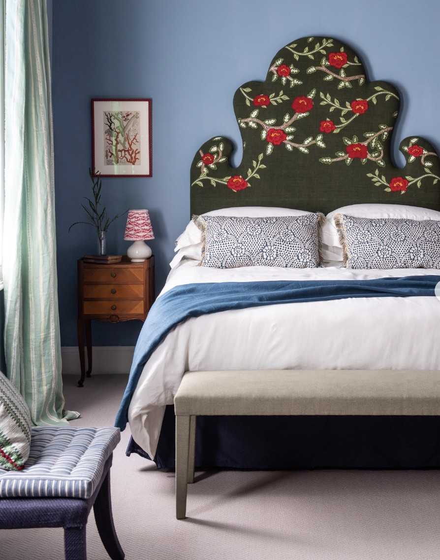 Blue Accent Wall And Green Floral Headboard In Bedroom